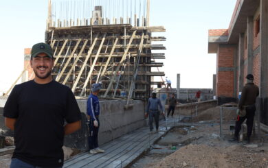 Mohammed stands with the governments new power station in the background