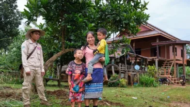 Ms. Vongvilay stands with one of her sons on her arm, and the other by her side smiling to the camera